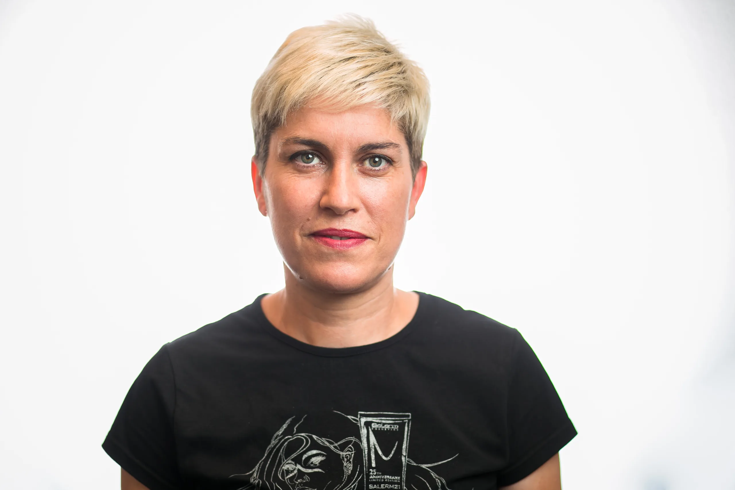 Retrato cercano de Sonia, peluquera, con una camiseta negra. La foto en color muestra su rostro con una expresión serena, fondo blanco.