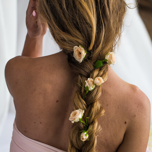 Joven con cabello largo y flores en el pelo, en Cabelo Estilistas Vigo, especialistas en productos veganos y naturales.